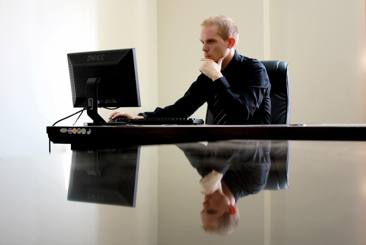 Homme concentré devant son écran d'ordinateur, dans un bureau