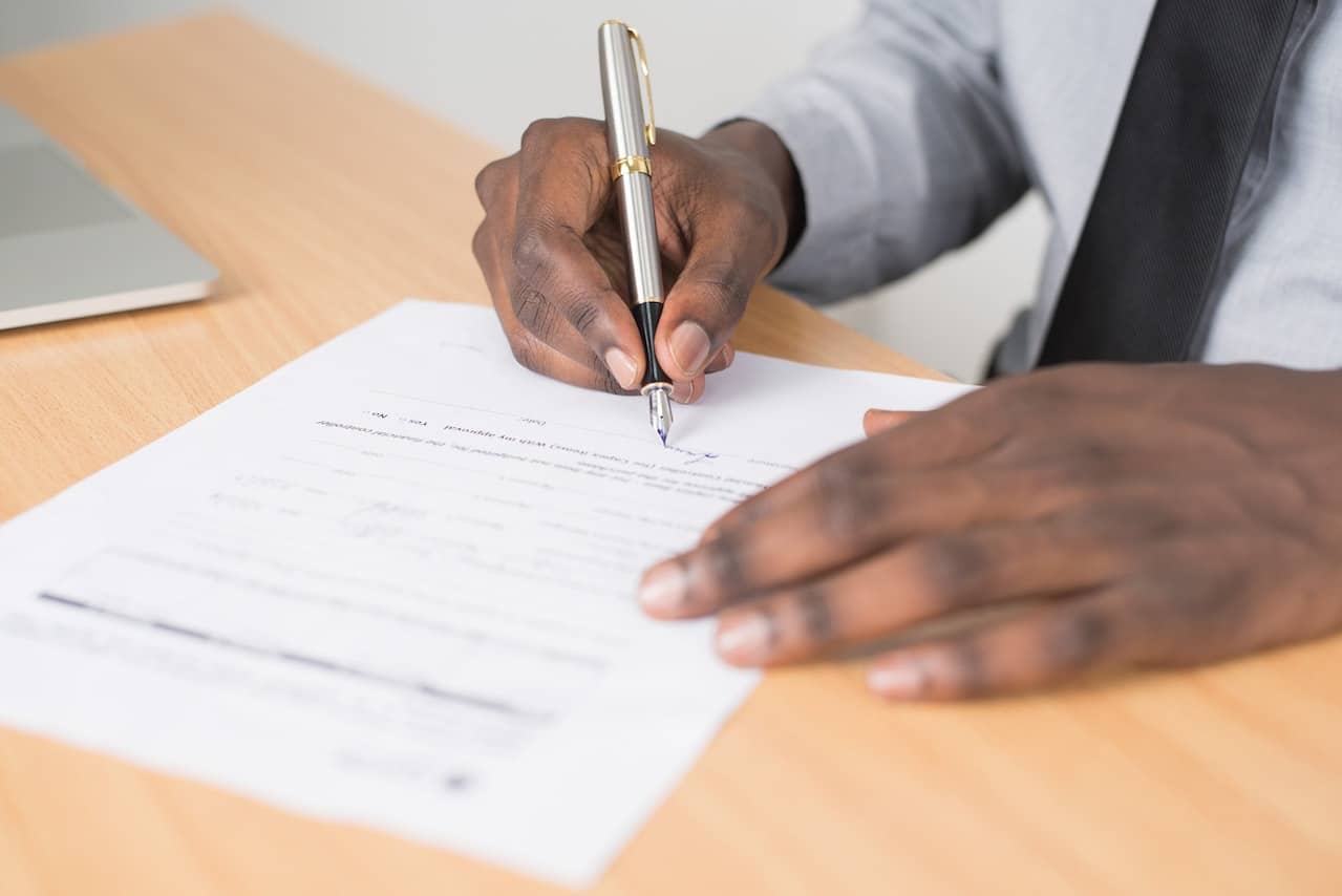 Homme noir qui signe un formulaire manuscrit